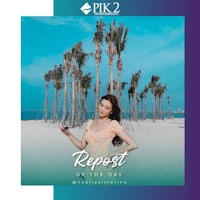 a woman in a dress standing on a beach with palm trees