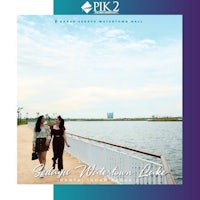 two women standing on a boardwalk next to a body of water