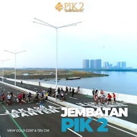 a group of people riding bikes on a road with the words jembatan pik 2