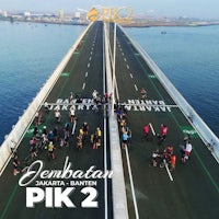 a group of people on a bridge with the words jembatan pik 2