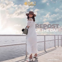 a woman in a white dress standing on a dock