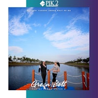 two people standing on a dock next to a lake